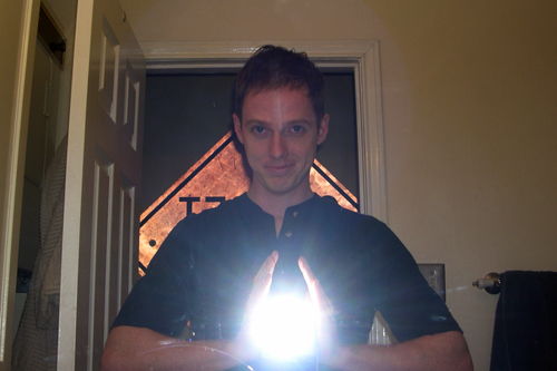 Self-portrait taken in bathroom mirror with camera flash positioned to create 'magic energy ball' effect.