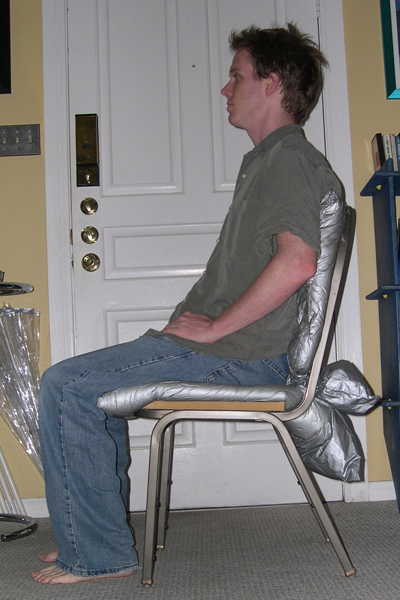 Profile view of the chair with me sitting in it, demonstrating conformation of foam-in-place cells to body contours.